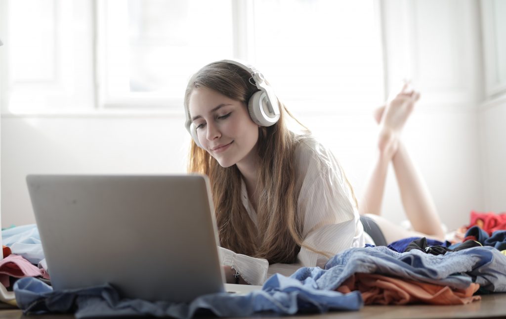 A women wearing headphones looking at a laptop